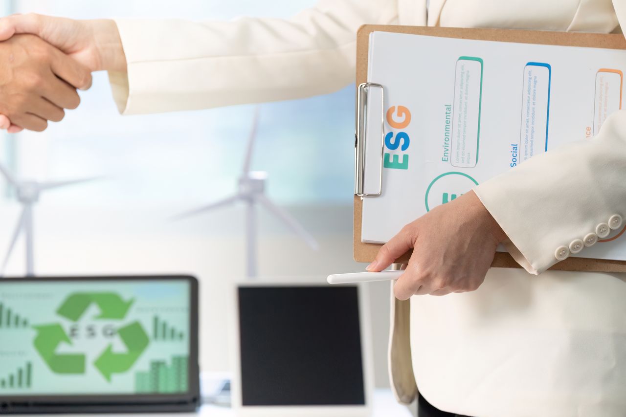 Professionnels scellant une transaction ESG : M&A, optimisation de portefeuille et reporting durable pour décisions stratégiques.